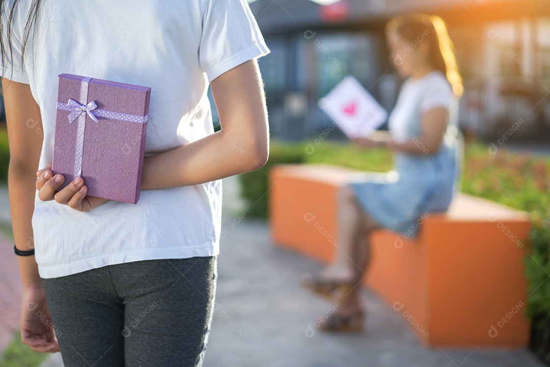 Mãe lendo cartão postal e crianças segurando surpresa de caixa de presente