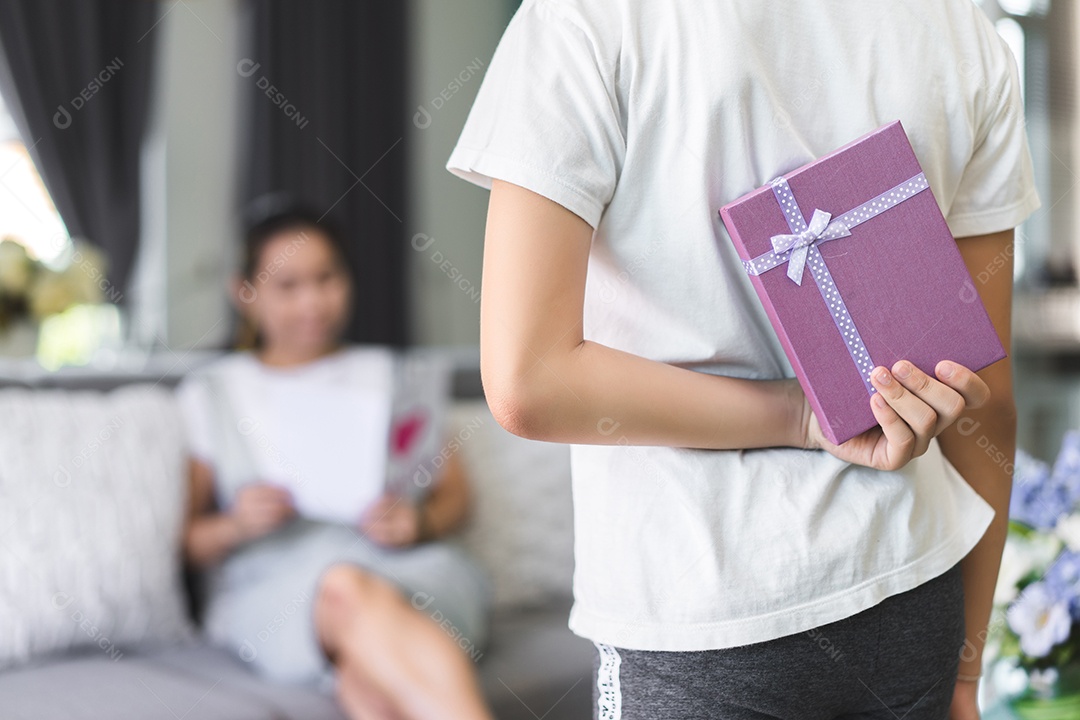 Mãe lendo cartão postal de e crianças segurando surpresa de caixa de presente