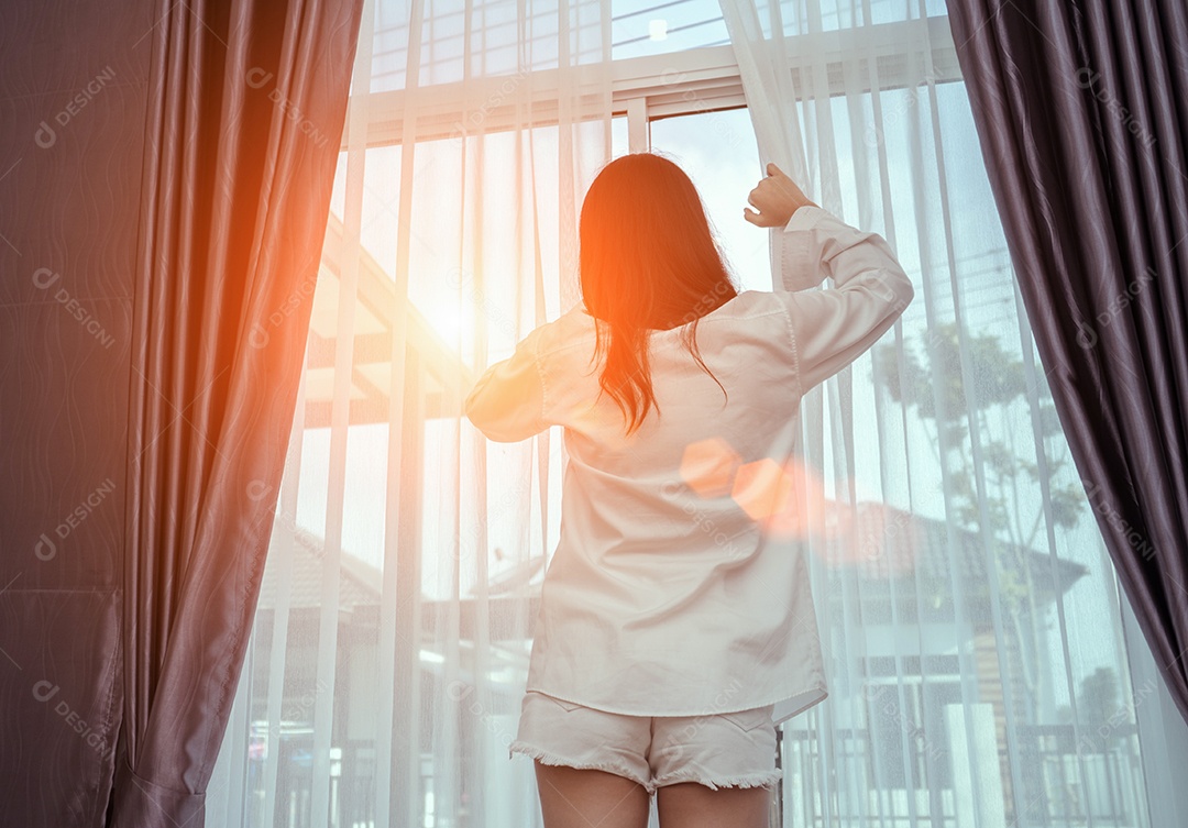 A mulher acorda de manhã e abre a janela depois de acordar