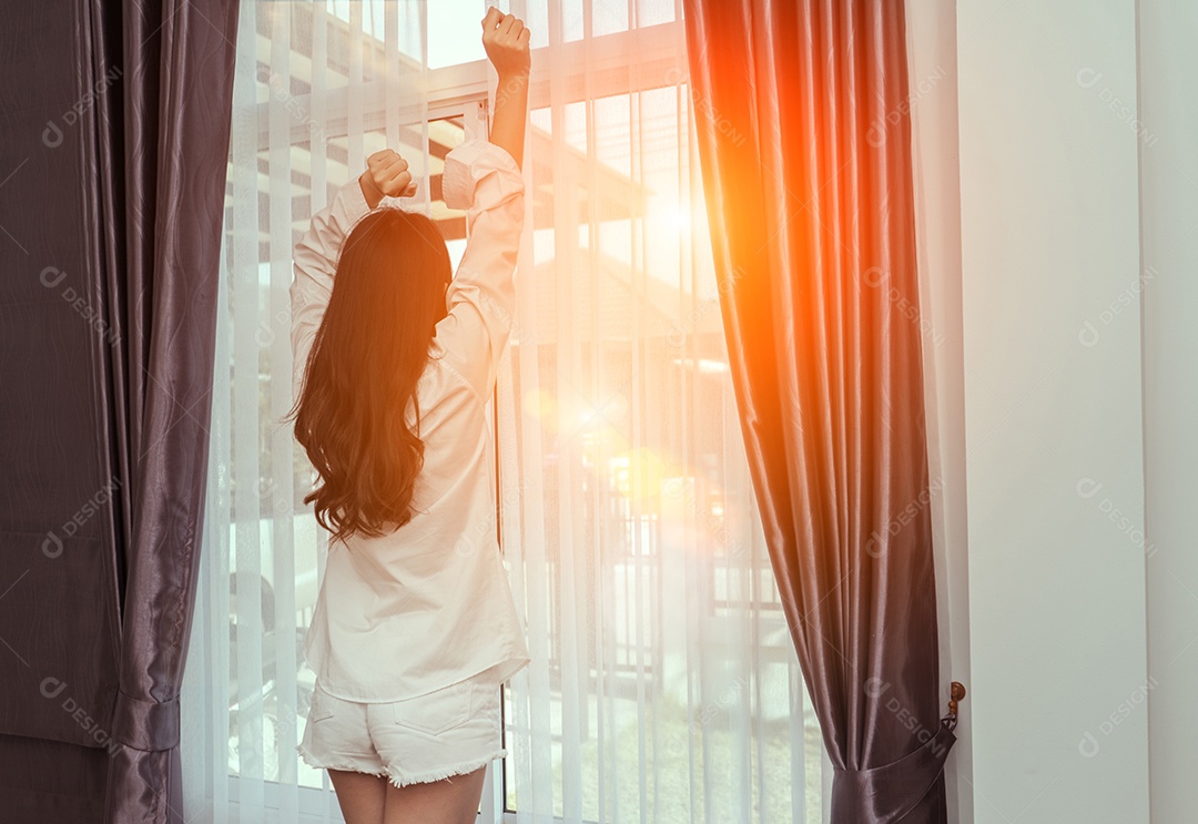 A mulher acorda de manhã e abre a janela depois de acordar