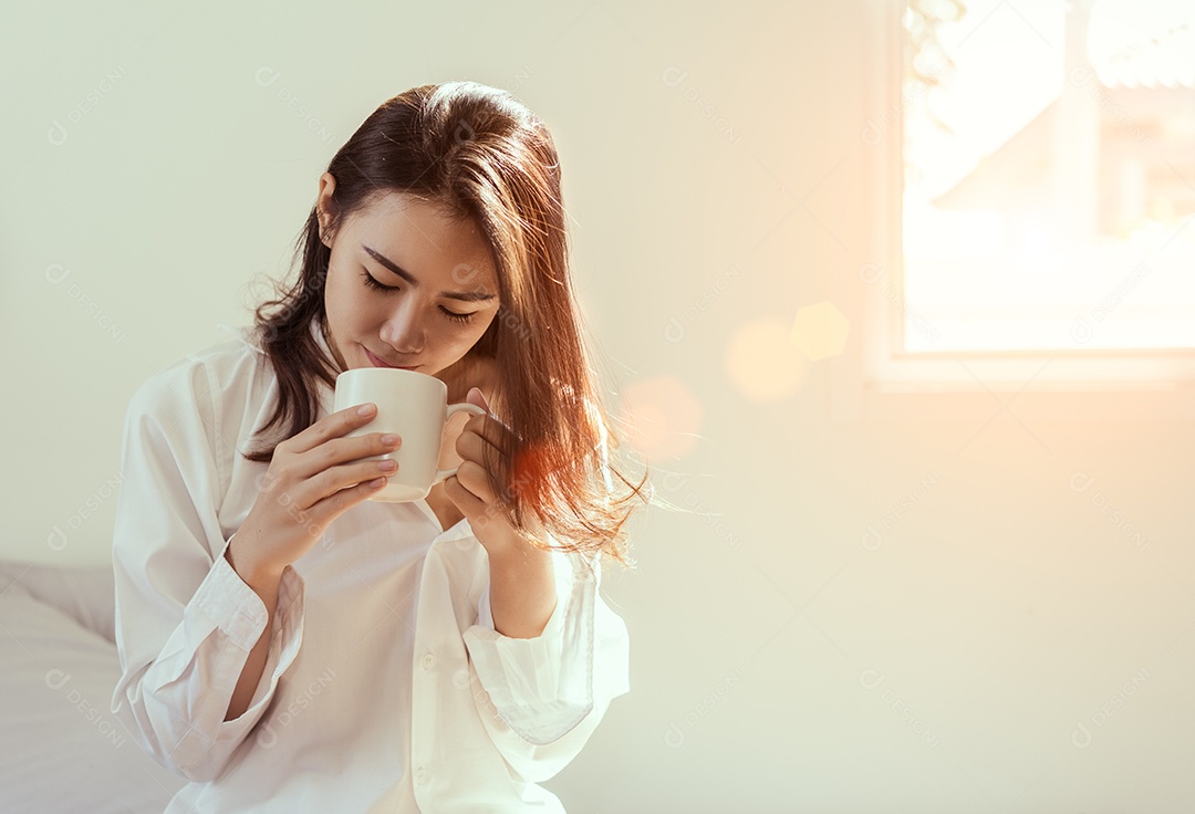 Mulher asiática tomando café da manhã na janela do quarto