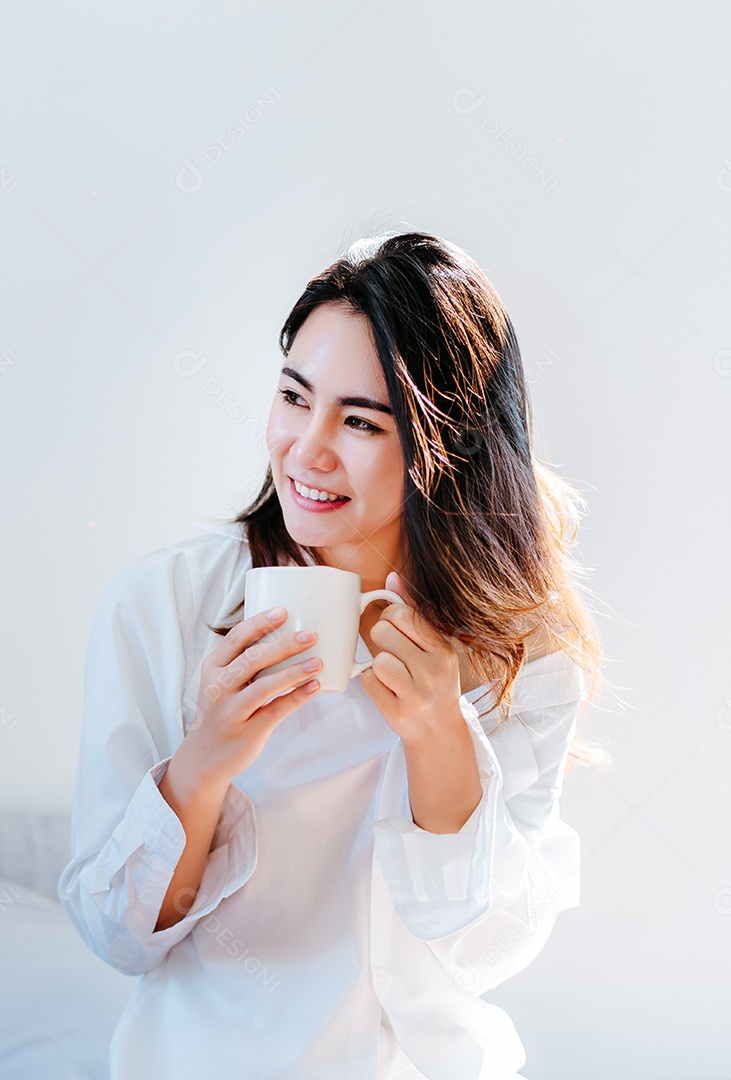 Mulher asiática tomando café da manhã na janela do quarto