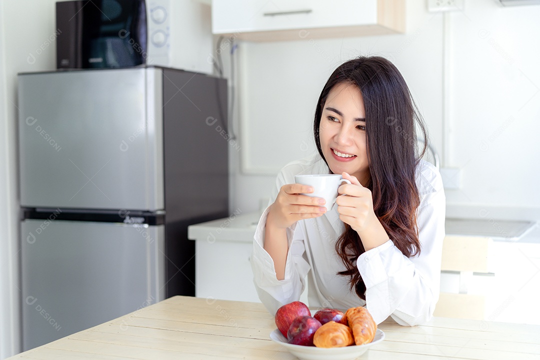 Mulher asiática tomando café pela manhã e comendo pão, maçã, fruta, comida saudável