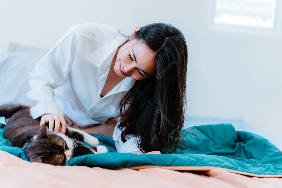 Mulher asiática brincando com gato de estimação pela manhã