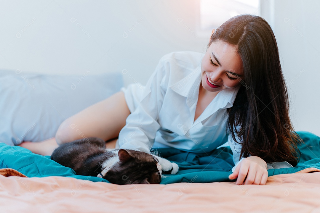 Mulher asiática brincando com gato de estimação pela manhã