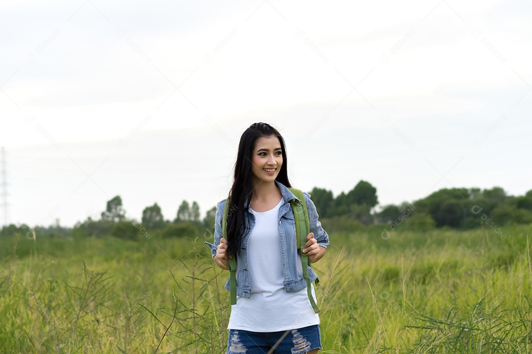 Menina asiática com mochila, mapas abertos, localização viagem na floresta