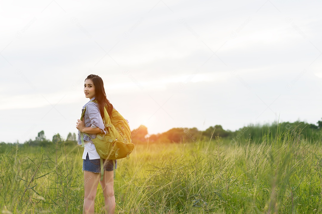 Menina asiática com mochila, mapas abertos, localização viagem na floresta
