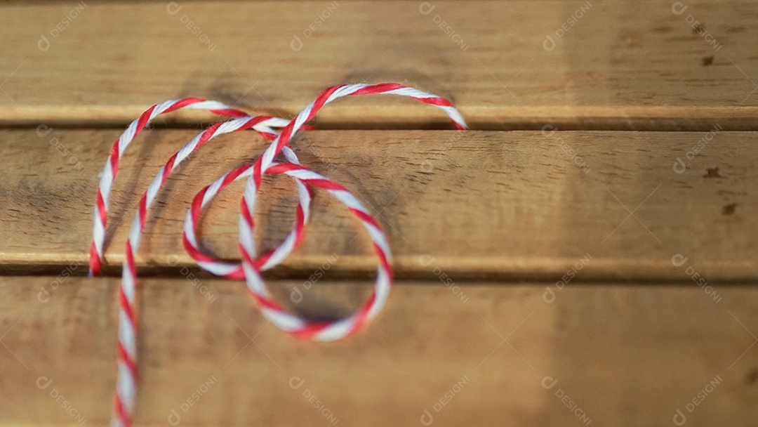 Detalhes de cordão vermelho e branco sobre madeira