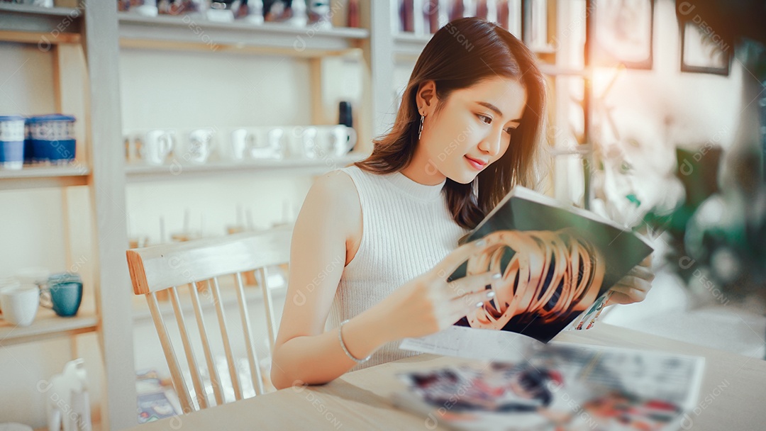 Menina asiática lendo livro de moda