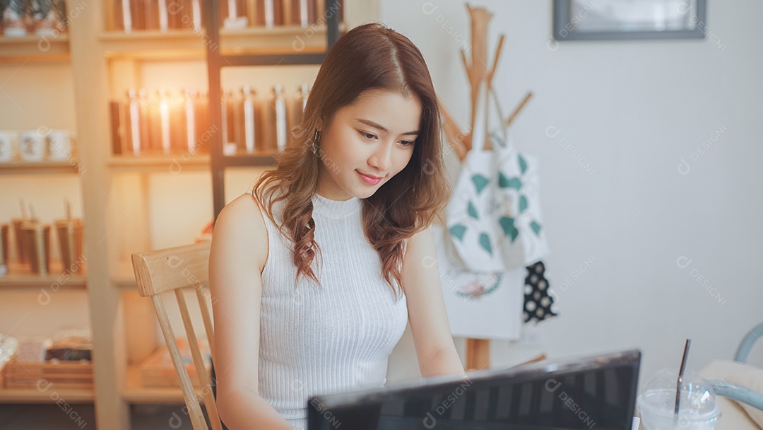 A felicidade de uma jovem asiática sentada trabalhando