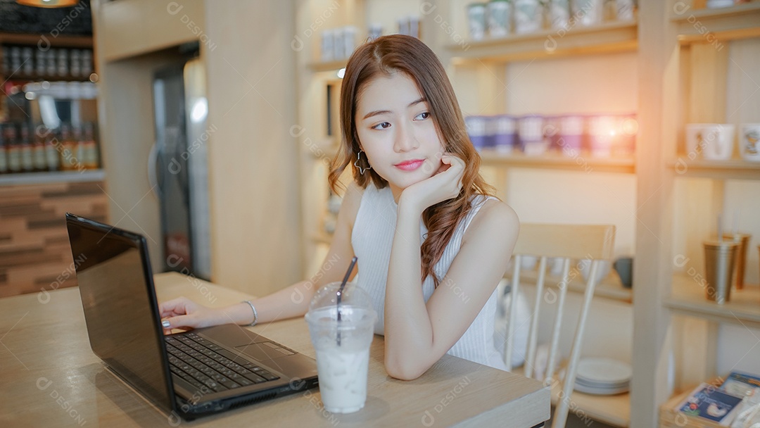 A felicidade de uma jovem asiática sentada trabalhando