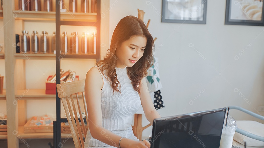 A felicidade de uma jovem asiática sentada trabalhando