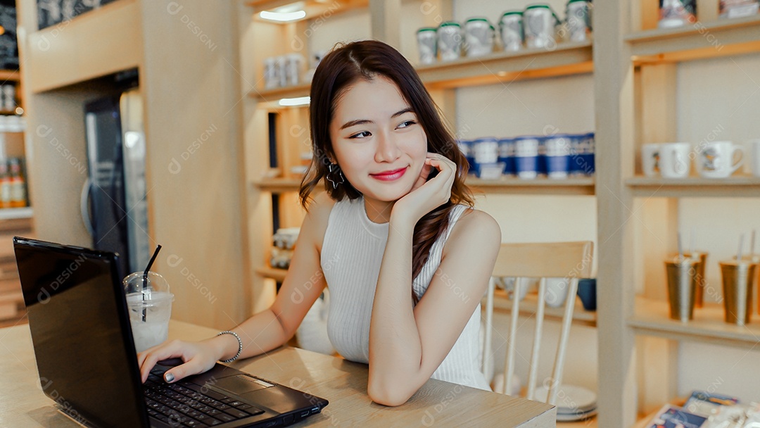 A felicidade de uma jovem asiática sentada trabalhando