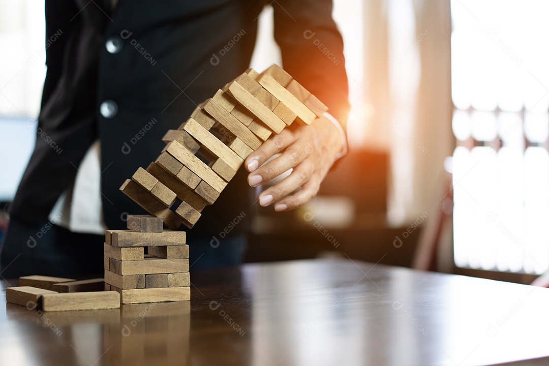 A mão do empresário que puxa o bloco de madeira