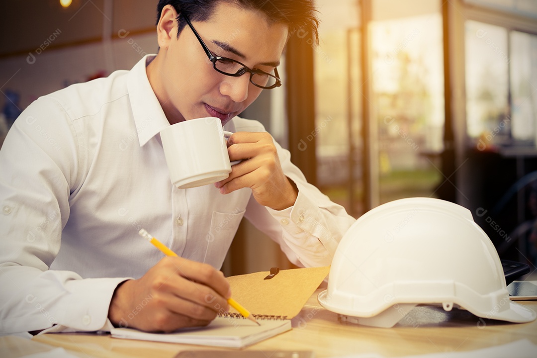 Engenheiro trabalhando na mesa de escritório com planta, plano de papel, documento