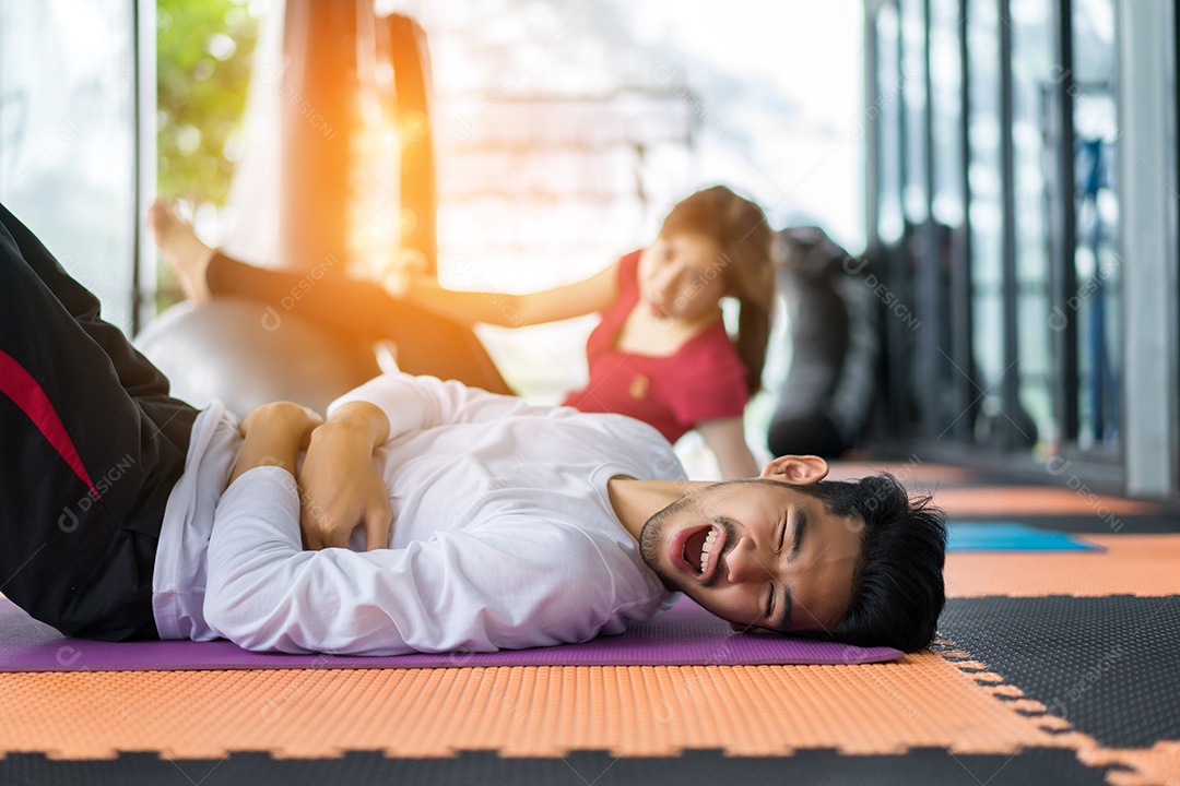 Jovens asiáticos e mulheres feridos praticam exercícios aeróbicos com bola de ioga