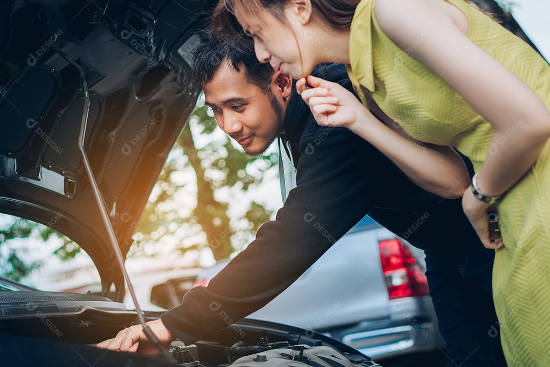 O homem verifica e repara o carro problemático da mulher