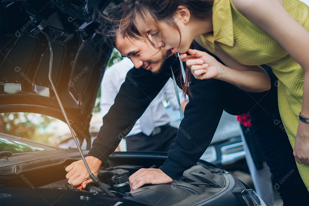 O homem verifica e repara o carro problemático da mulher