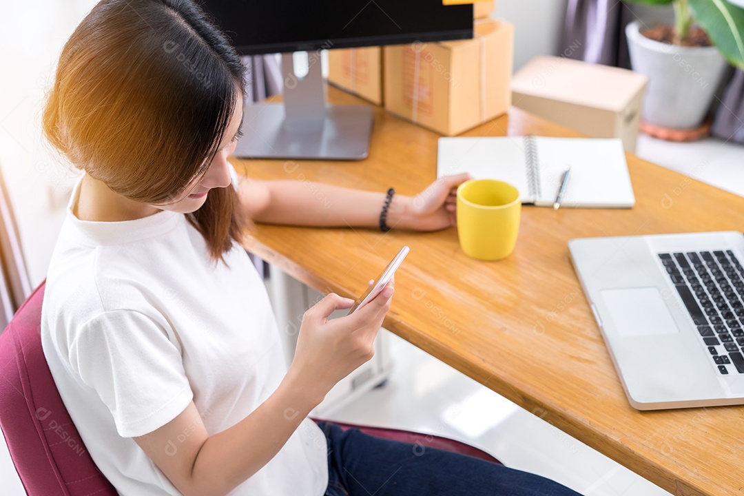 Jovem asiática freelancer pequena empresa privada trabalhando em escritório doméstico com laptop