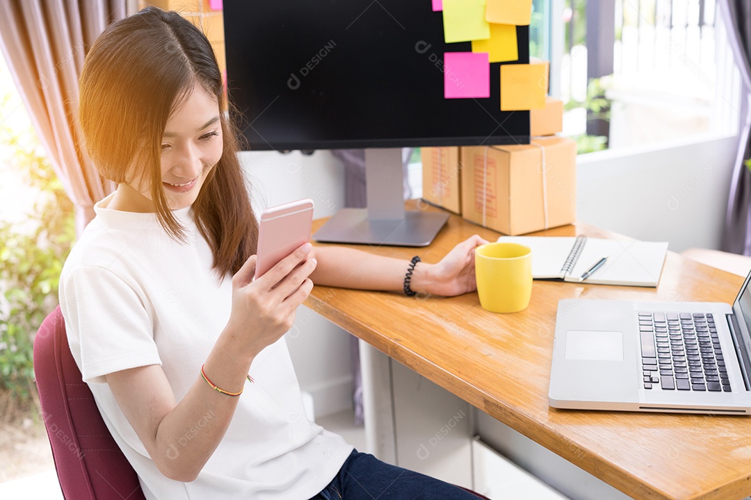 Jovem asiática freelancer pequena empresa privada trabalhando em escritório doméstico com laptop