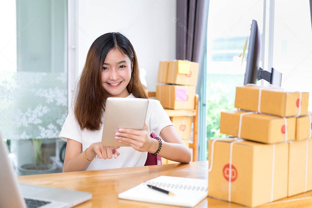 Jovem asiática freelancer de negócios privada trabalhando em escritório doméstico com tablet