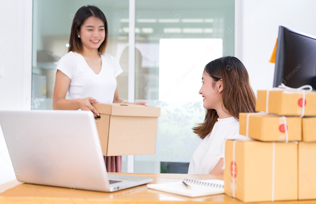 Jovem asiática juntos negócios freelancer privados trabalhando no escritório doméstico segurando a caixa de embalagem