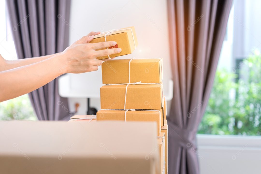 Jovem asiática freelancer de negócios entrega de caixa de produtos para clientes