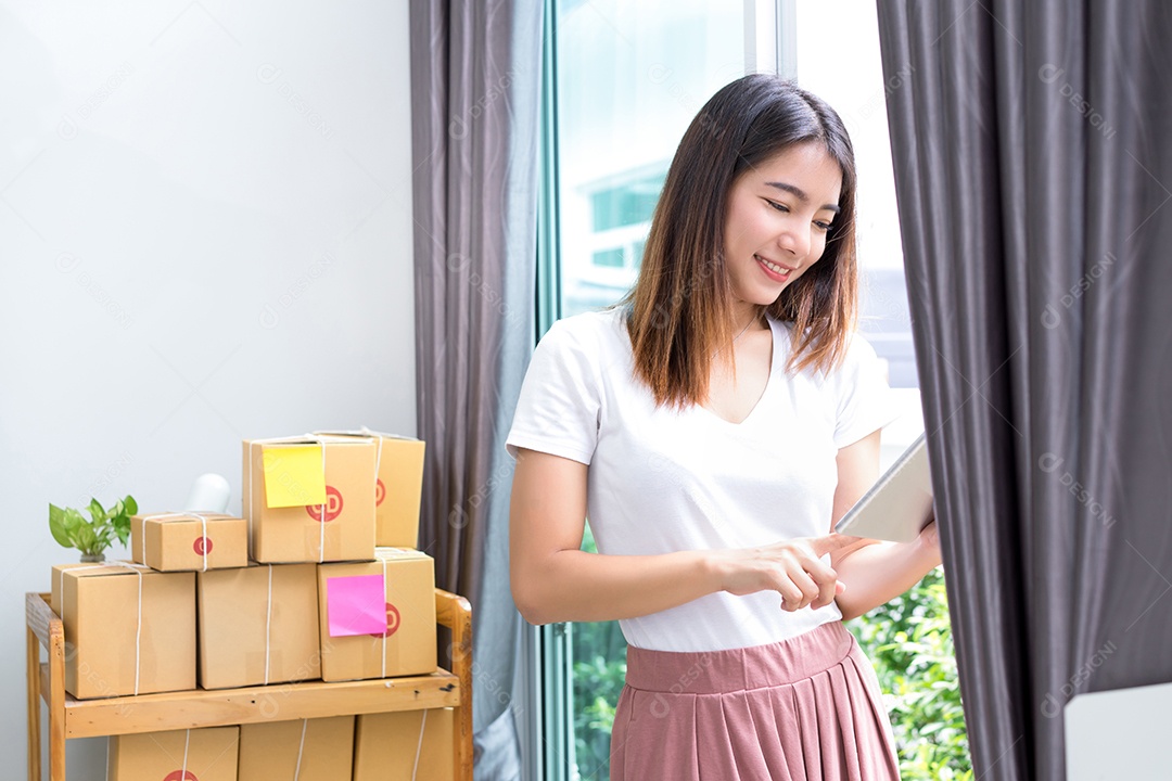 Jovem asiática freelancer de negócios entrega de caixa de produtos para clientes