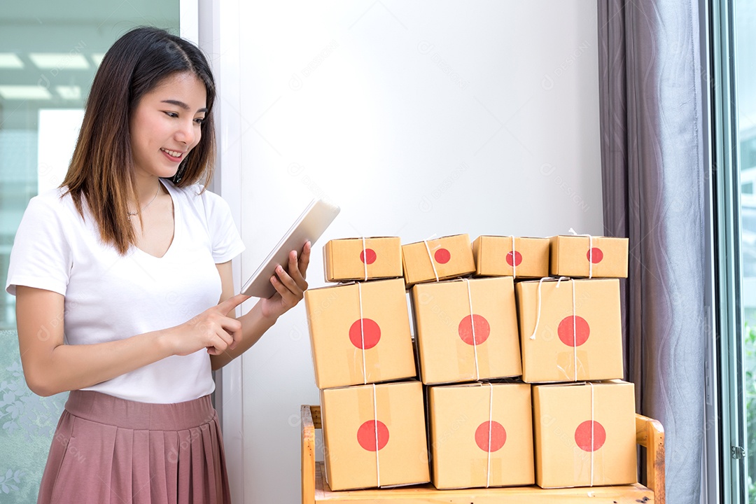 Jovem asiática freelancer de negócios entrega de caixa de produtos para clientes