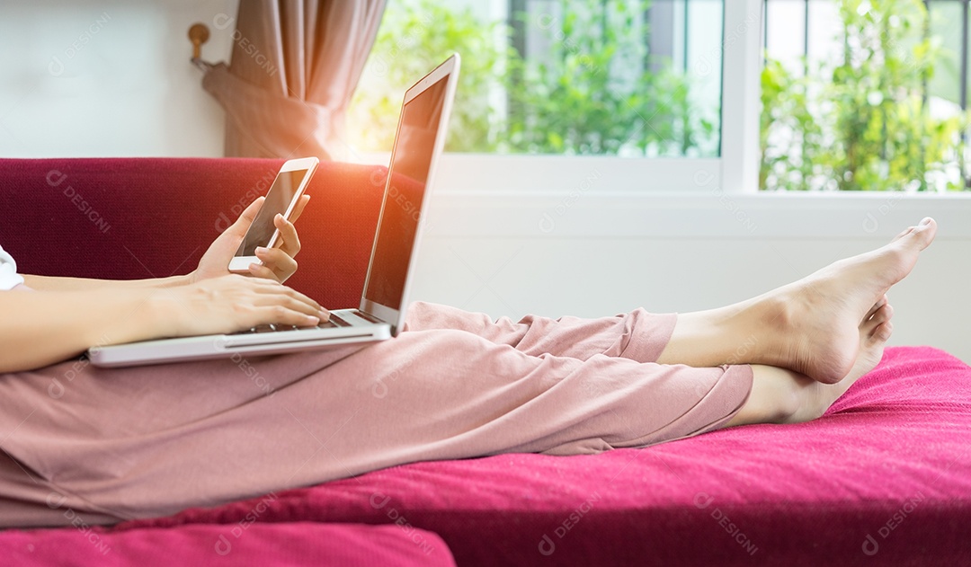 Mãos de mulher segurando telefone com laptop