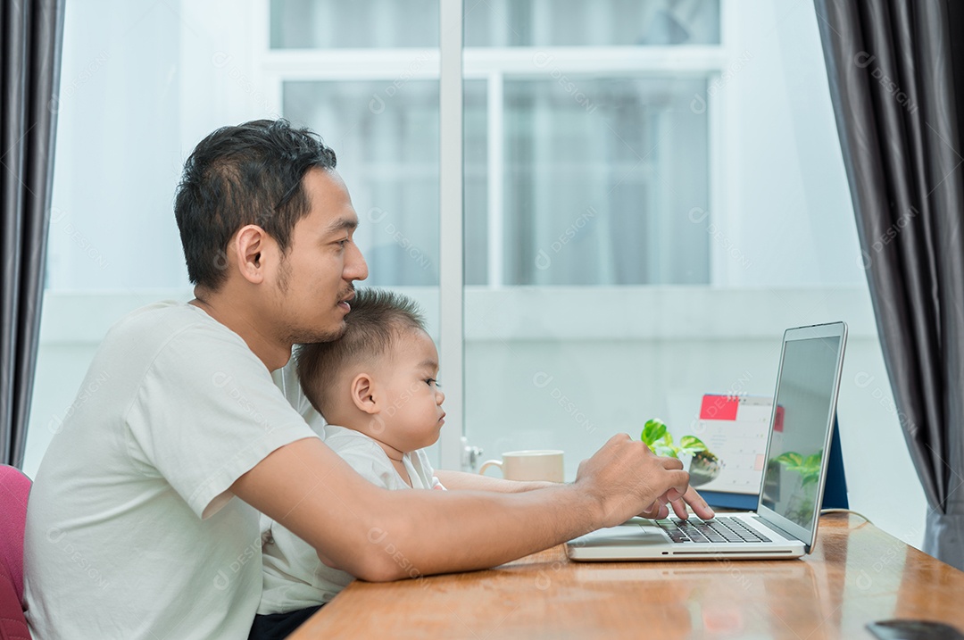 Pai asiático e filho pequeno digitando algo no computador portátil