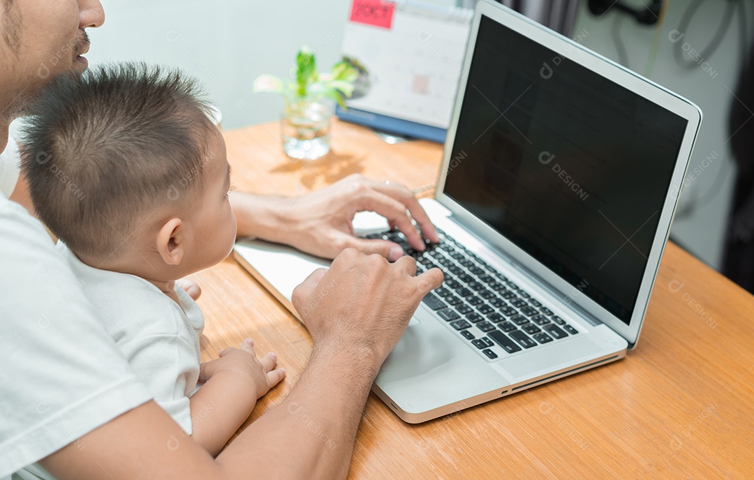 Pai asiático e filho pequeno digitando algo no computador