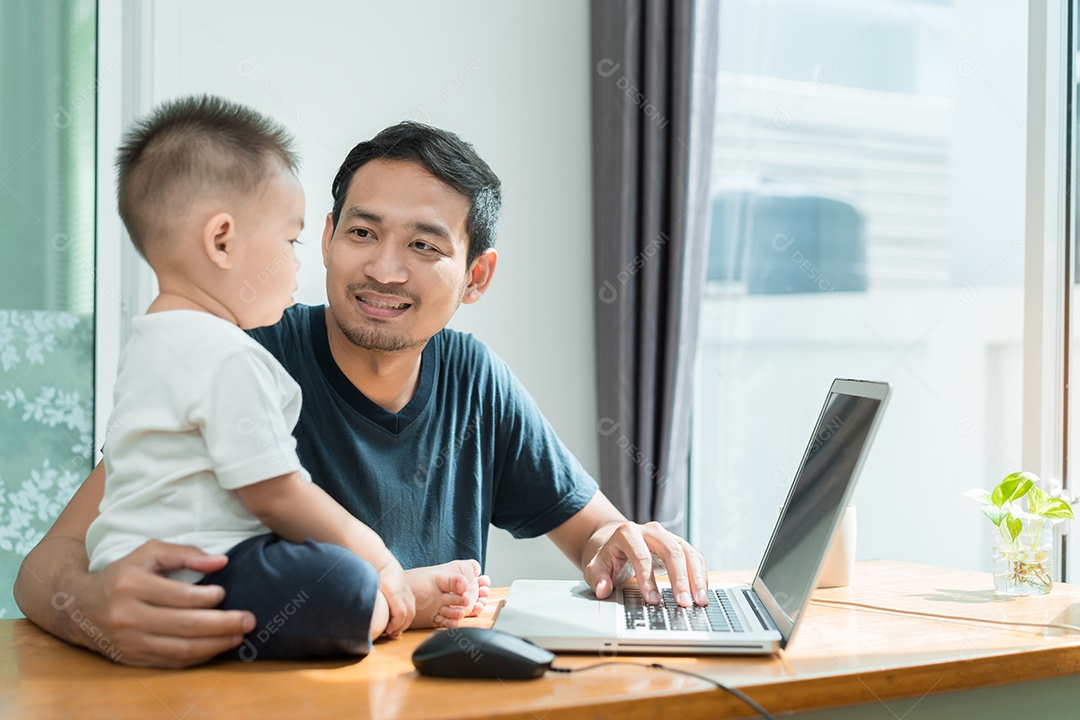 Pai asiático e filho pequeno assistindo algo no laptop