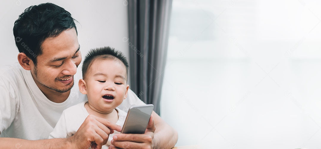 Pai asiático e filho pequeno assistindo vídeo de smartphone