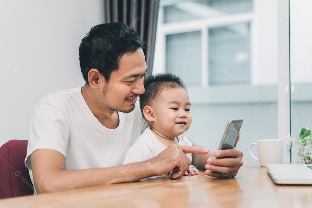 Pai asiático e filho pequeno assistindo vídeo de smartphone