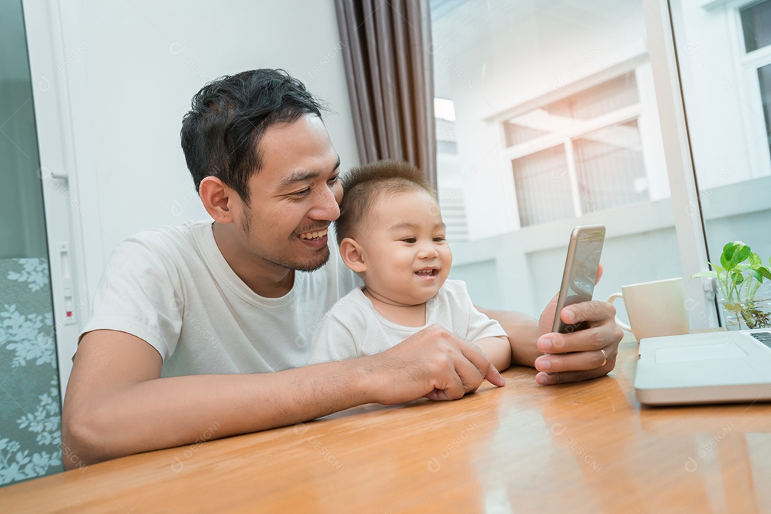 Pai asiático e filho pequeno assistindo vídeo de smartphone