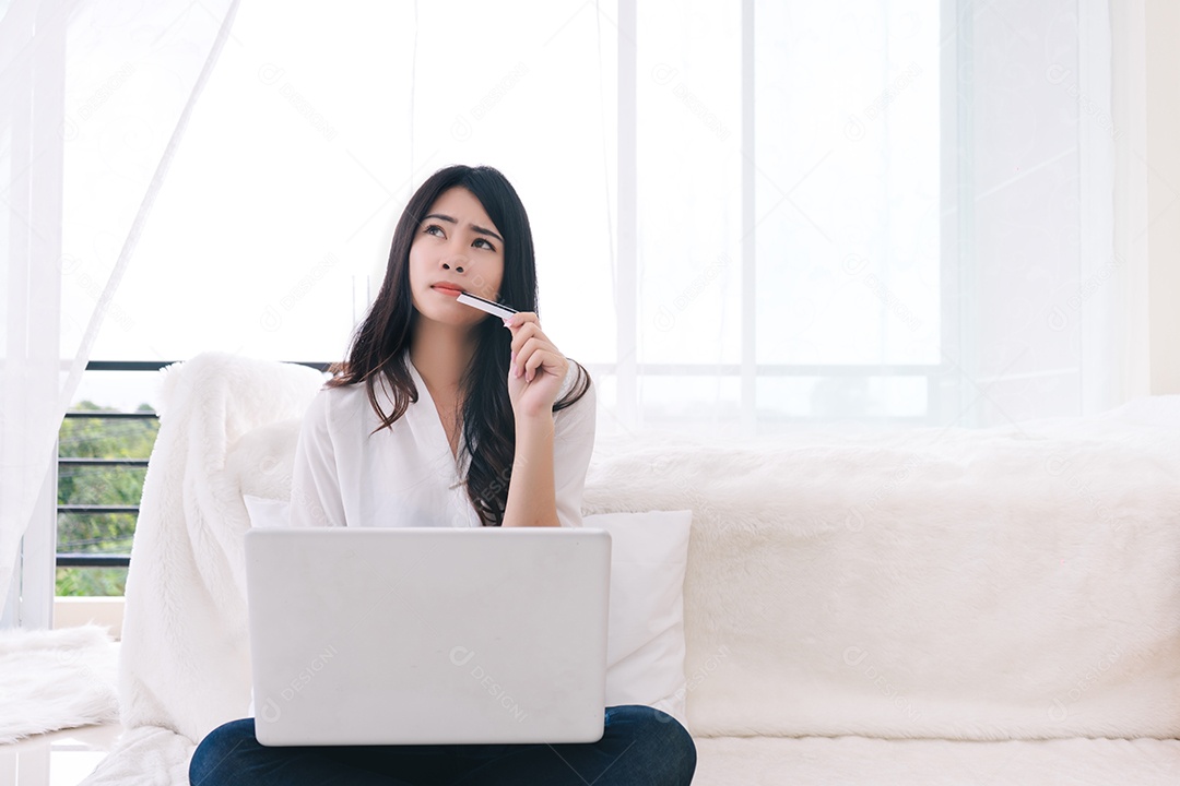 Compras on-line de mulher asiática segurando cartão de crédito