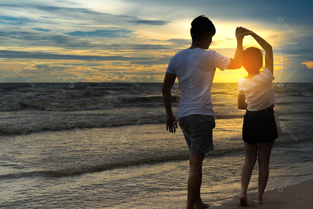 Jovem casal romântico dança na praia