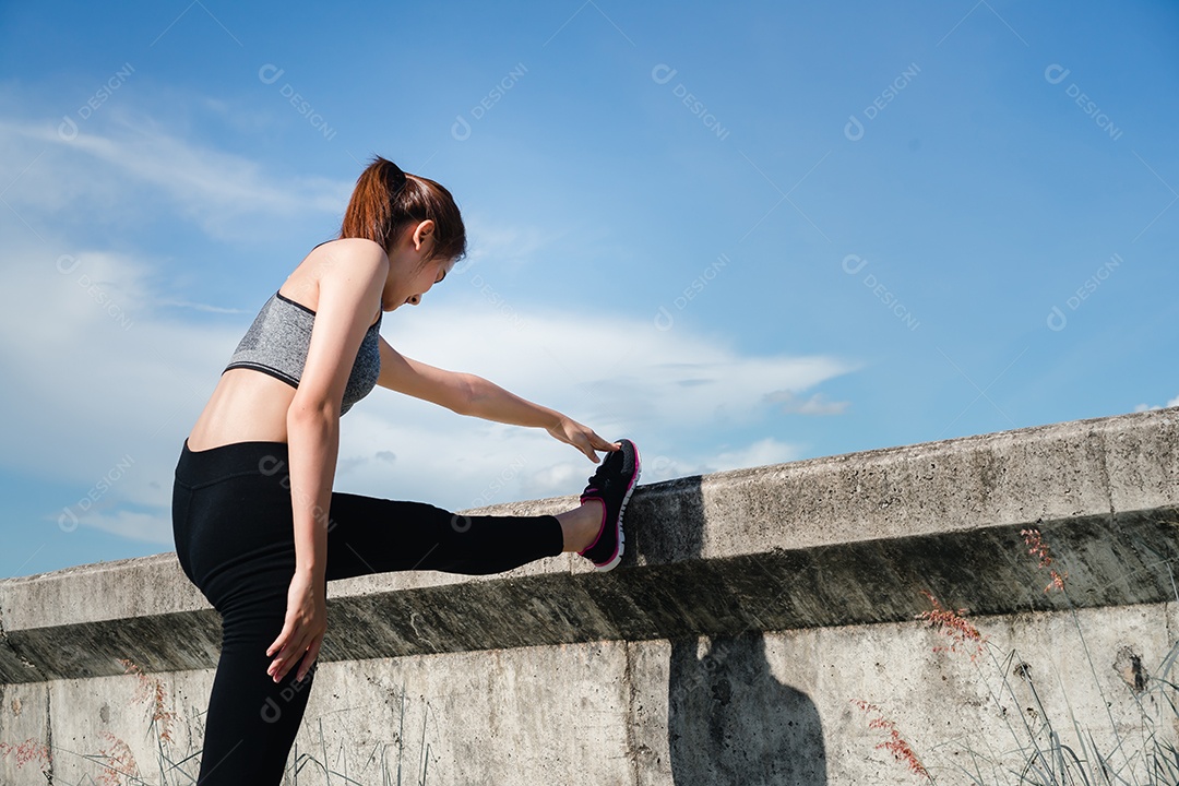 Jovem asiática alongando para se exercitar