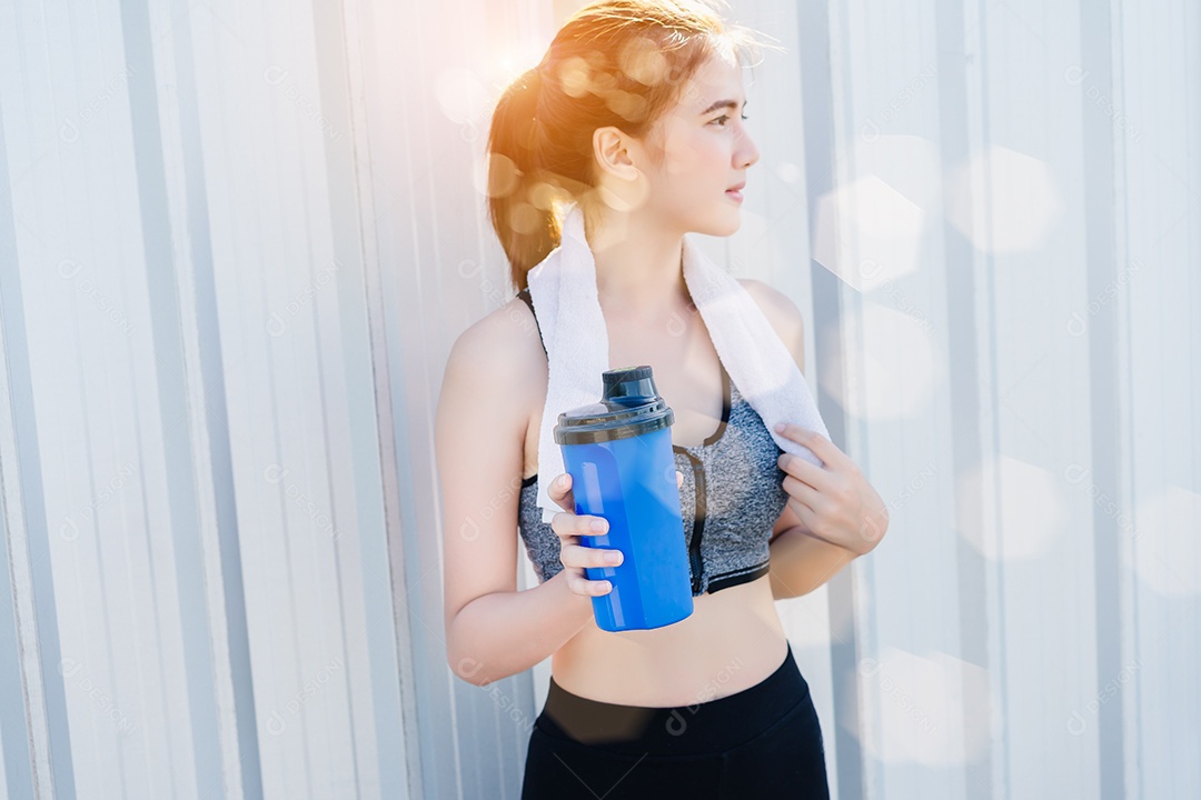 Jovem asiática segurando a garrafa de água azul