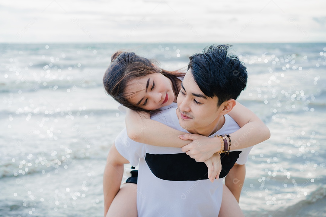 Jovem conversando com garota na praia, casal se divertindo