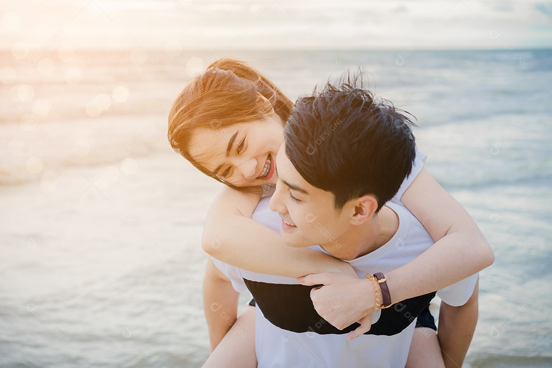 Jovem conversando com garota na praia, casal se divertindo