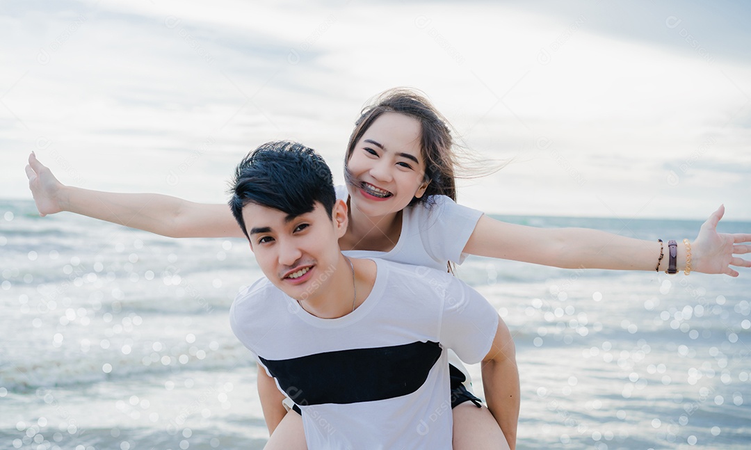 Jovem conversando com garota na praia, casal se divertindo
