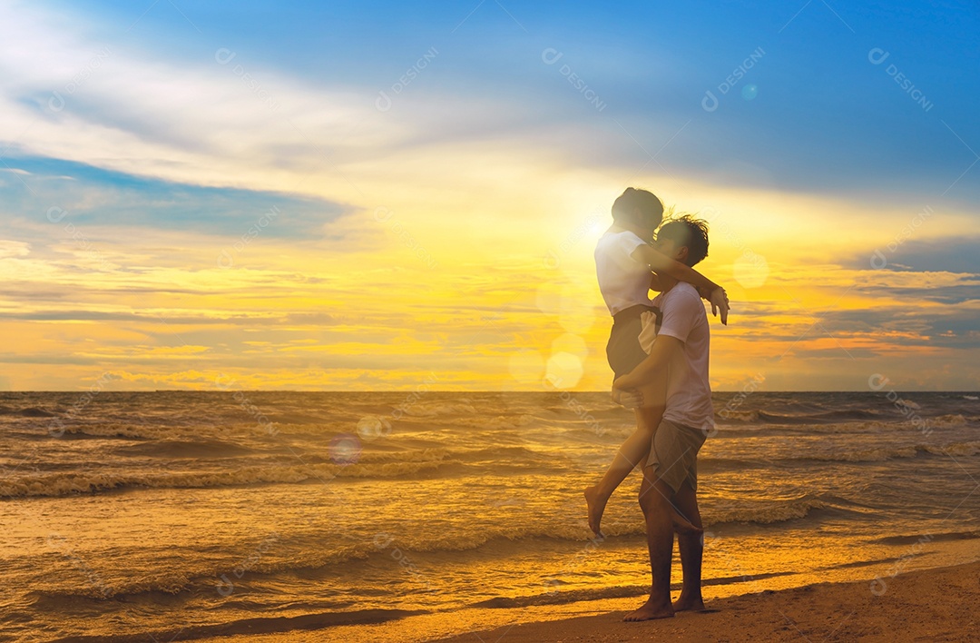 Homem e menina caminhando nas férias pôr do sol à beira-mar na praia