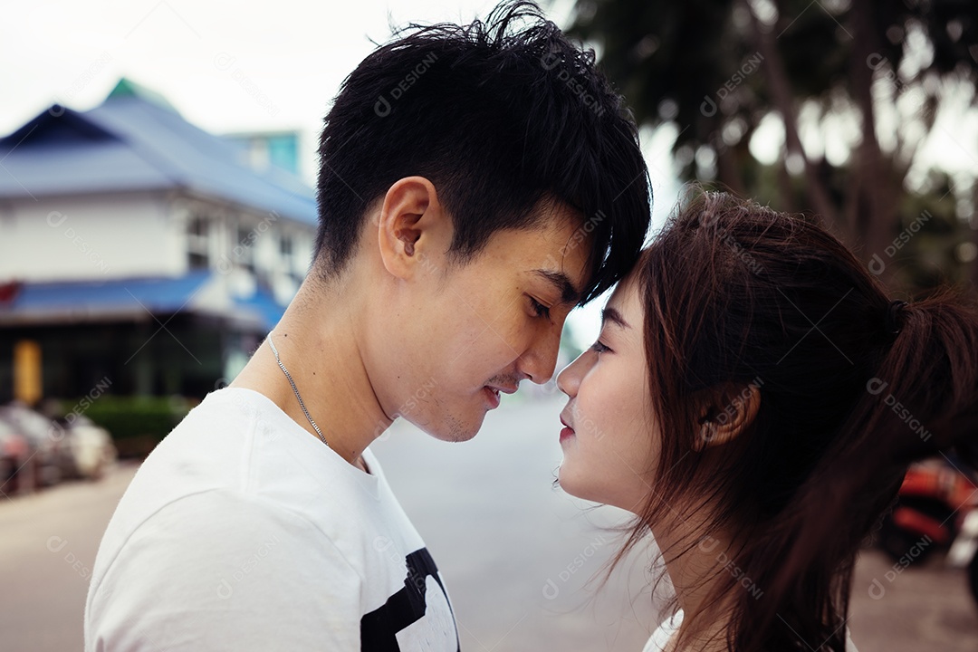 Casal abraçando e sorrindo felicidade ao ar livre