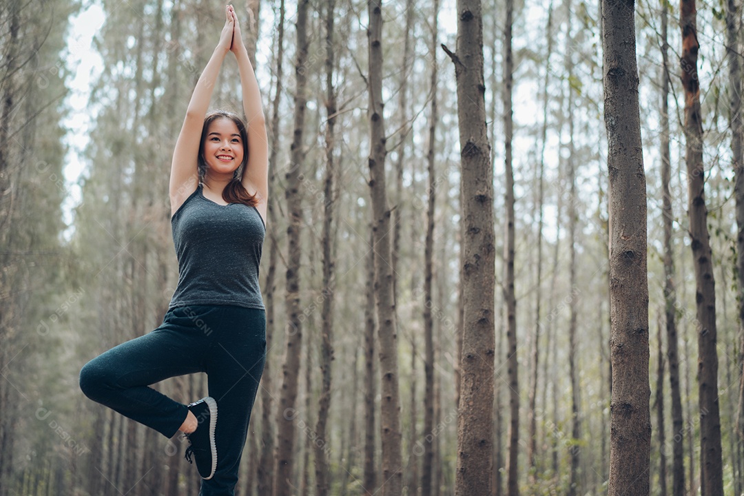 Mulher bonita praticando pose de ioga na natureza da floresta