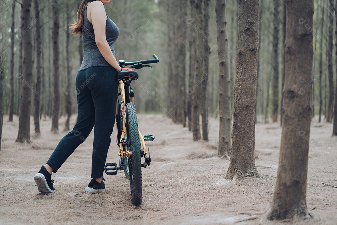 Mulher andando de bicicleta na floresta