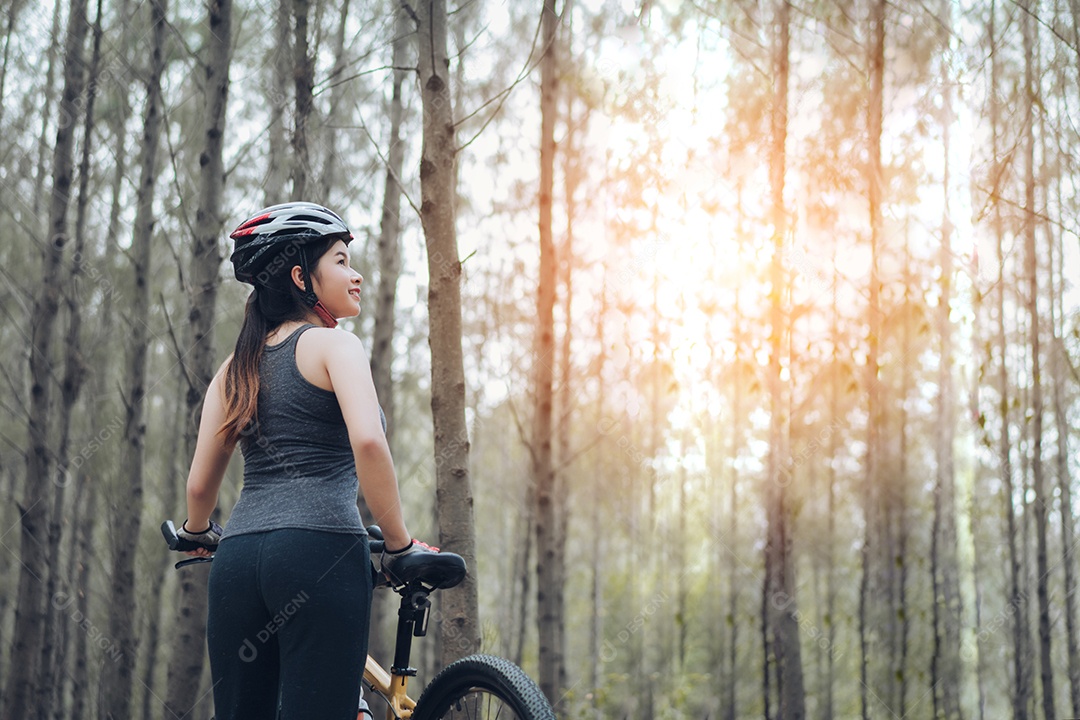 Mulher andando de bicicleta na floresta