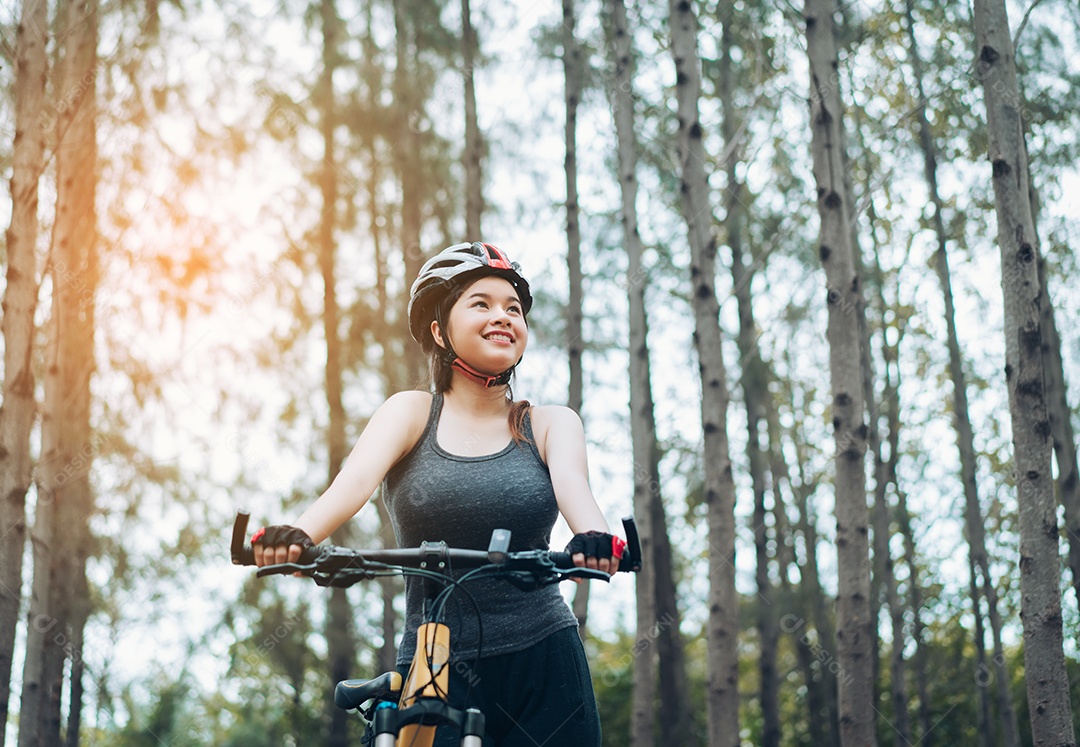Mulher andando de bicicleta na floresta