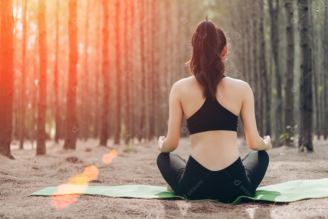 Jovem mulher fazendo ioga na floresta